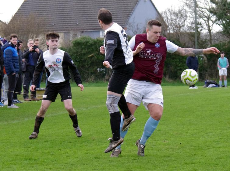 Sean Hannon and Steve Thomas both go for the ball